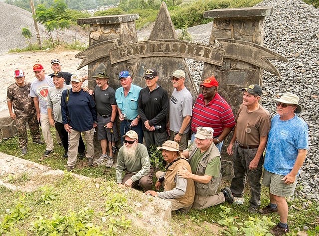 Photo by JOHN RIEDY/TGGF Director of Photography
The entire group of 11 Marines and one Navy Corpsman pose with the Camp Reasoner sign during their TGGF sponsored trip to Vietnam in March.