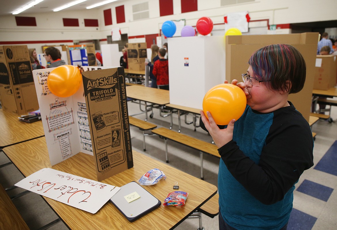 Sixth-grader Michael Spoerl blows air into a balloon for his science experiment Wednesday afternoon at Canfield Middle School. (LOREN BENOIT/Press)