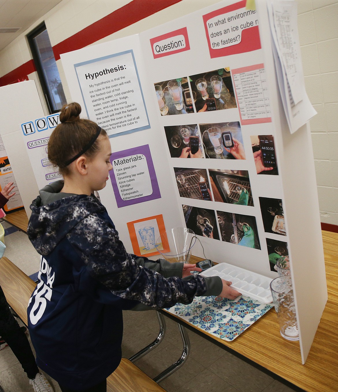 Sixth-grader Cammi Padilla sets up her science experiment prior to judging Wednesday afternoon at Canfield Middle School. Padilla&#146;s experiment explored how fast ice cubes melt in different solutions and temperatures. Her ice cubes melted faster under running running water than in an oven and in standing hot water.  (LOREN BENOIT/Press)