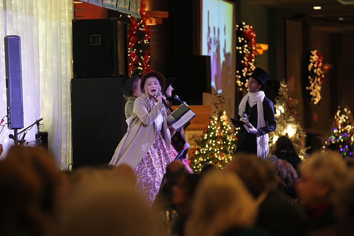 DEVIN WEEKS/Press 
Red Bird Theater actress Kylee Lavier as &#147;Margaret&#148; sings a Christmas carol into the microphone Saturday morning while she and her colleagues perform a piece of &#147;The Scrooge and Marley Annual Christmas Ball&#148; for guests of the Festival of Trees Brunch in The Coeur d&#146;Alene Resort. Also pictured: Brianna Gilge (directly behind Lavier), Marie Hunt and Brandon Miller.