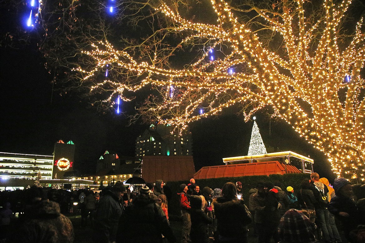 Families gather underneath a fully lit-up tree as the Christmas tree atop the Hagadone Corporate Offices during the Coeur d'Alene Resort Holiday Light Show. (LOREN BENOIT/Press)