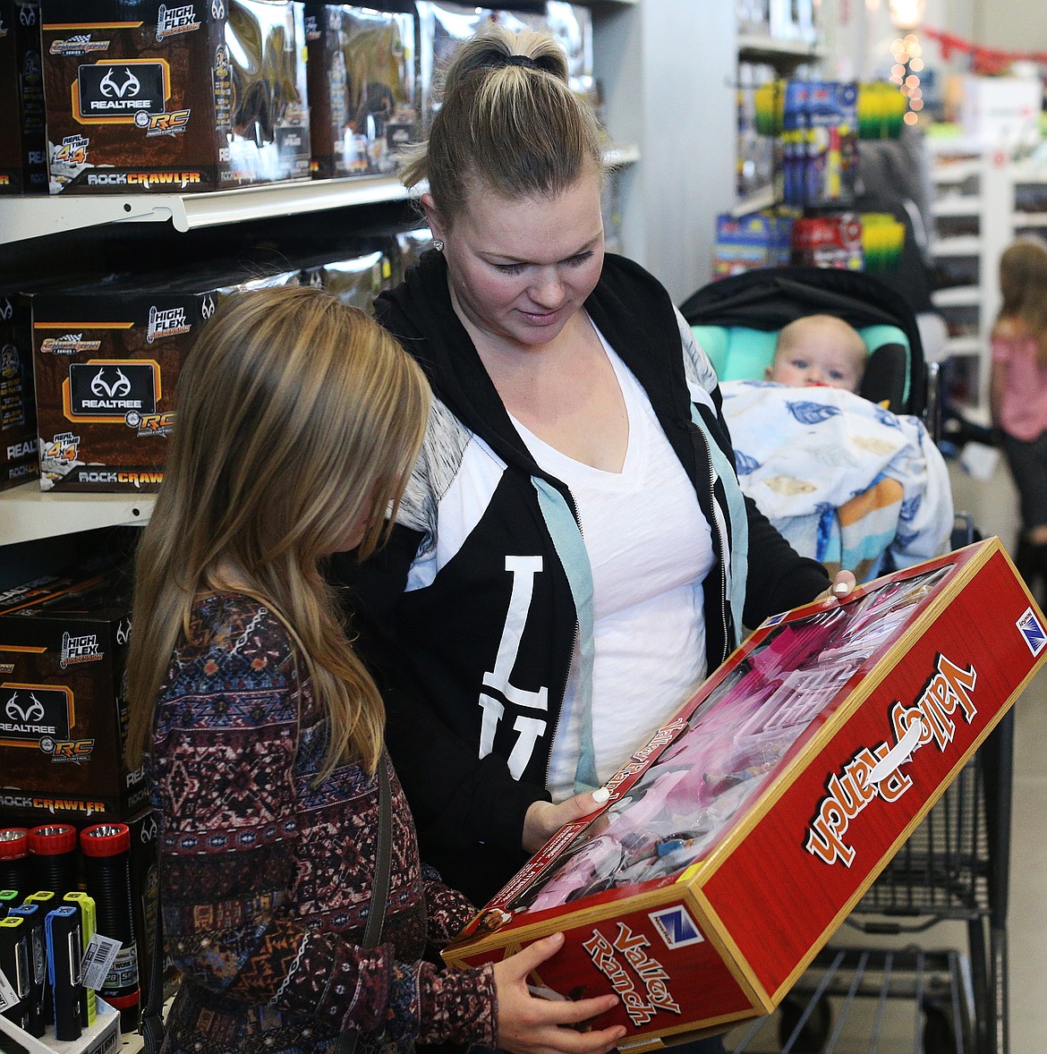 Brittany Cazier and her daughter Alexis, 10, pick out a gift for baby sister during Black Friday at North 40 Outfitters. (LOREN BENOIT/Press)