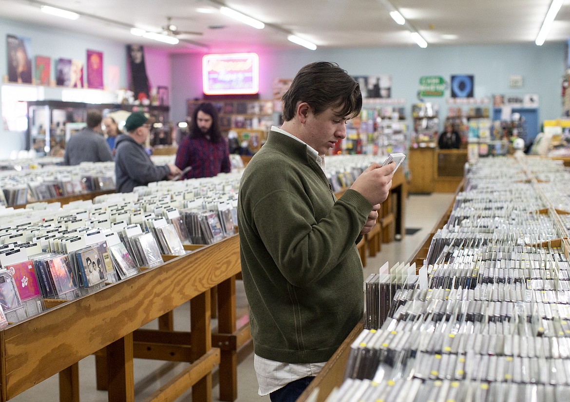 Nolan Foster looks at a Brantley Gilbert CD while he shops at The Long Ear on Tuesday. Foster comes to the store to find blues and rock artists to jam to on his guitar. (LOREN BENOIT/Press)