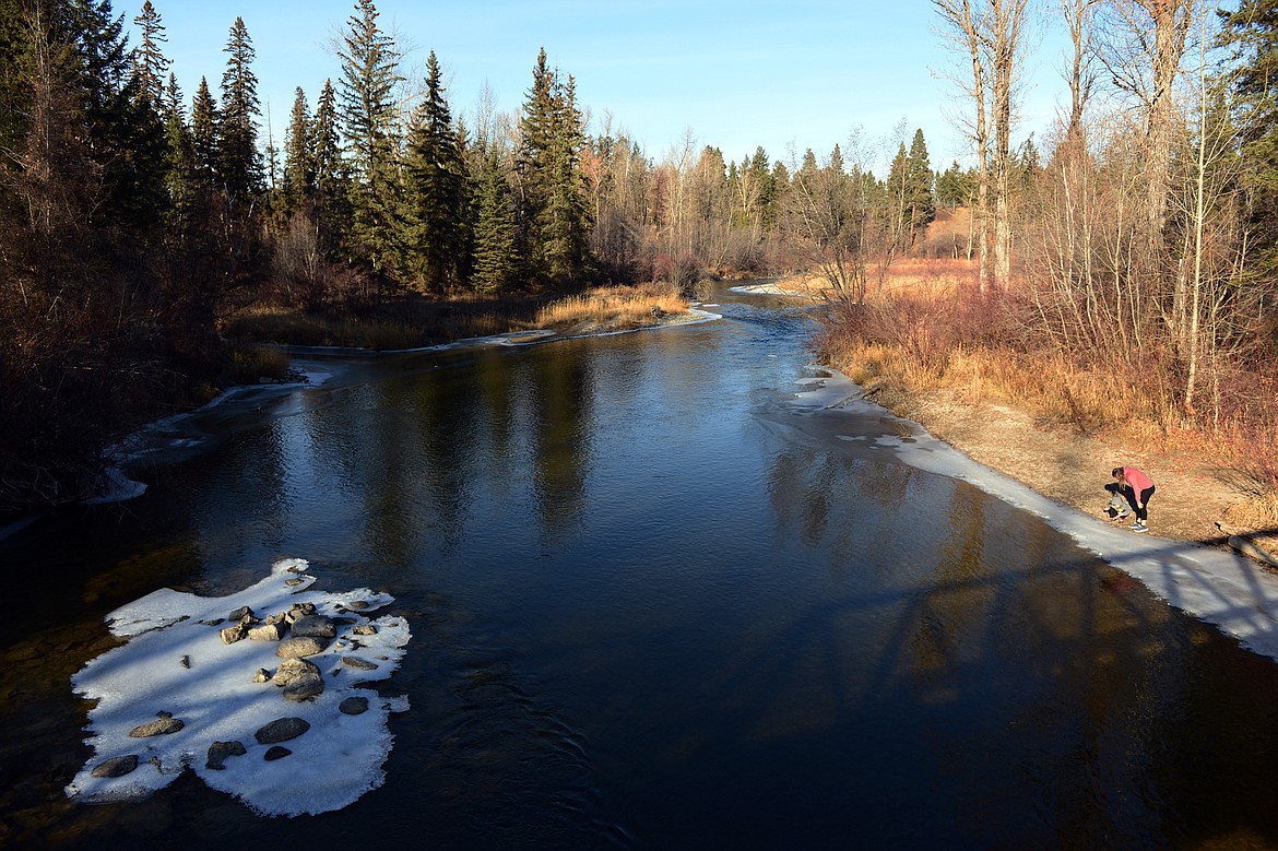 Jessica Hannon and her son Noah, of Kalispell, check out the ice along the Stillwater River during their afternoon at Lawrence Park on Tuesday, Nov. 20. (Casey Kreider/Daily Inter Lake)