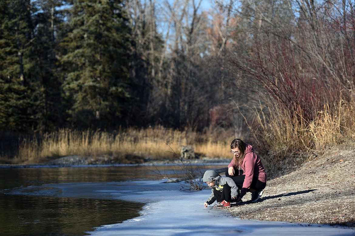 Jessica Hannon and her son Noah, of Kalispell, check out the ice along the Stillwater River during their afternoon at Lawrence Park.