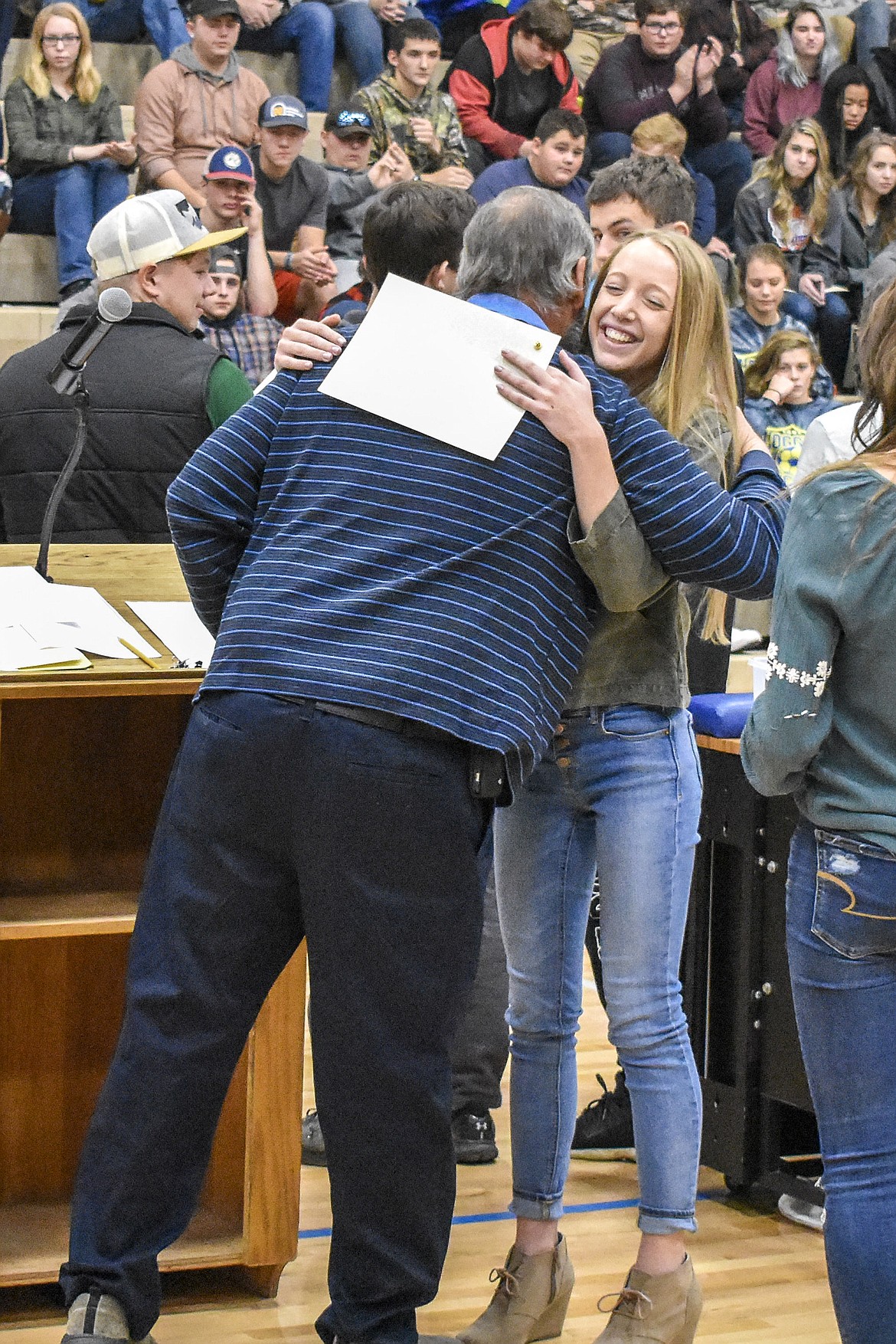 Libby High School golf Head Coach Dann Rohrer congratulates junior Sydney Croucher, recipient of the &#147;Most Inspirational&#148; team award for the girls golf team during the Fall Awards Assembly Thursday. (Ben Kibbey/The Western News)