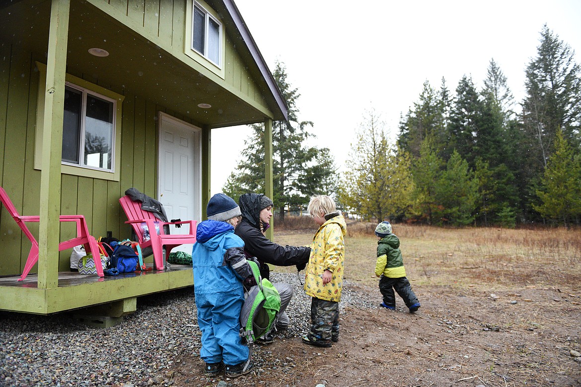 Teacher Kayla Nickells removes wet hats and gloves from students after a hike at Foxtail Forskola at Earthstar Farms in Whitefish on Wednesday, Oct. 31. Foxtail Forskola is a Scandinavian-inspired forest school where nature is the classroom. Children ages 3-6 spend nearly all of the school day outdoors learning social and emotional readiness through free play and nature-based activities on a 35-acre organic farm. (Casey Kreider/Daily Inter Lake)