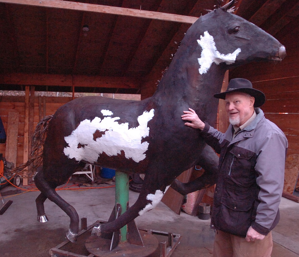 Kenton Pies&#146; first of five life-size depictions of wild horses of Horse Plains, Montana, is nearing completion. He is pictured with the first horse, a pinto, which weighs more than 600 pounds. Local artist Andy Gonzales welded the silver hooves on the sculpture. Among the other four wild horses to follow will be two adults and one colt at a gallop, and one rearing to show his status with the herd. (Joe Sova/Clark Fork Valley Press)