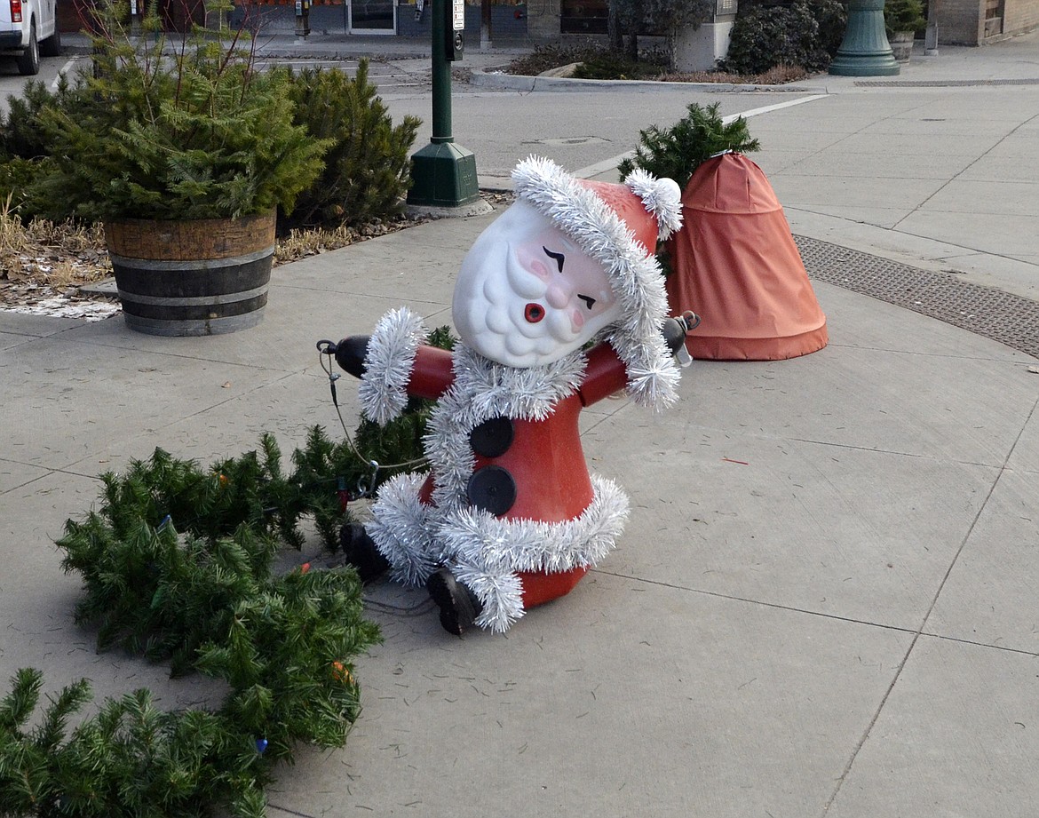 The Santa decoration sits on the ground before being lifted up across Central Avenue. (Heidi Desch/Whitefish Pilot)