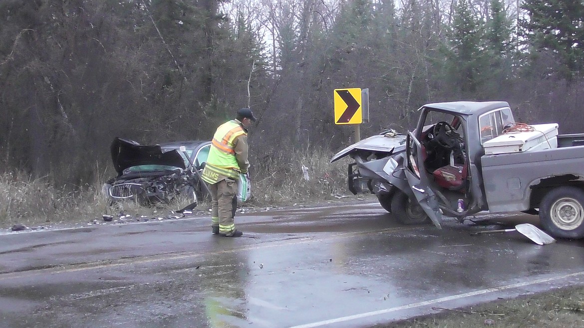 Evergreen Fire Rescue Chief Craig Williams spreads anti-skid material on icy Shady Lane to help his firefighters clean up an accident scene involving two vehicles Shady Lane Wednesday morning. Both drivers were taken to Kalispell Regional Medical Center. (Scott Shindledecker/Daily Inter Lake)