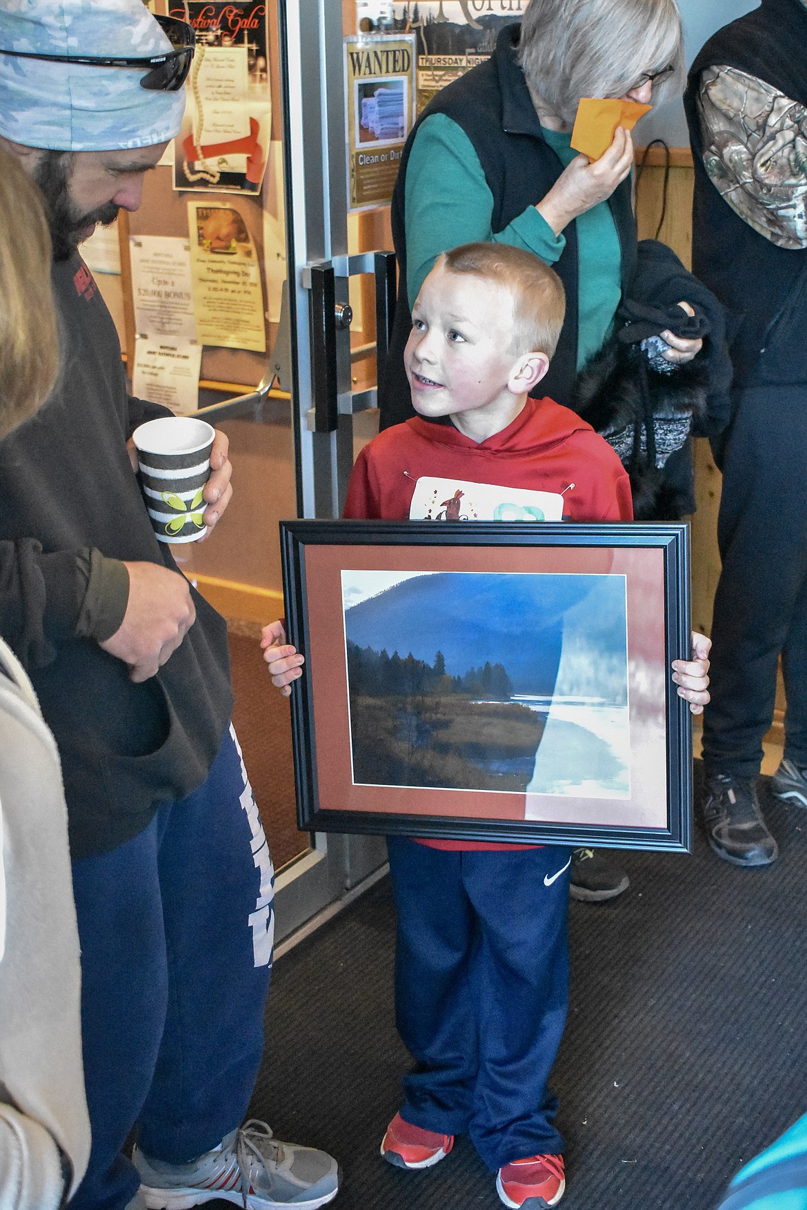 Cody Katzer Jr. talks to Cody Katzer while showing off the picture he won from the drawing following the Turkey Dash 5k fun run/walk on Saturday. (Ben Kibbey/The Western News)