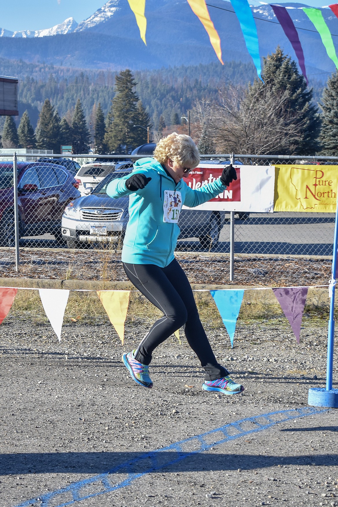Debbie Mickelson adds a little spring to her step as she crosses the finish line during the Turkey Dash 5k fun run. (Ben Kibbey/The Western News)