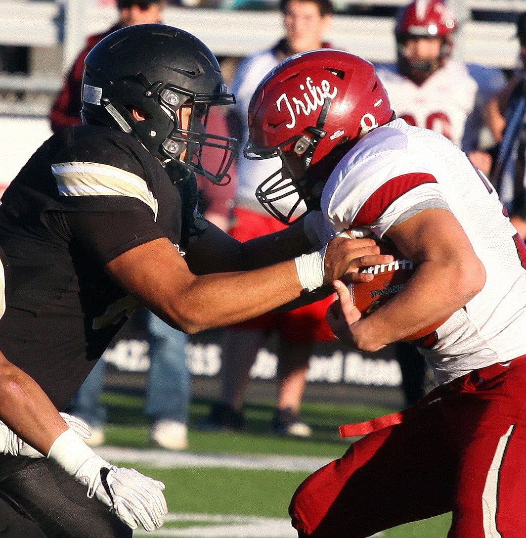 Rodney Harwood/Sun Tribune - Royal senior Javier Huitron (50) comes up to hit Coleville running back Trevor Morrison during third quarter action in Saturday's 1A state semifinal at Lions Field in Moses Lake. No. 5 Colville upset No. 1 Royal, ending the Knights 53-game winning streak.