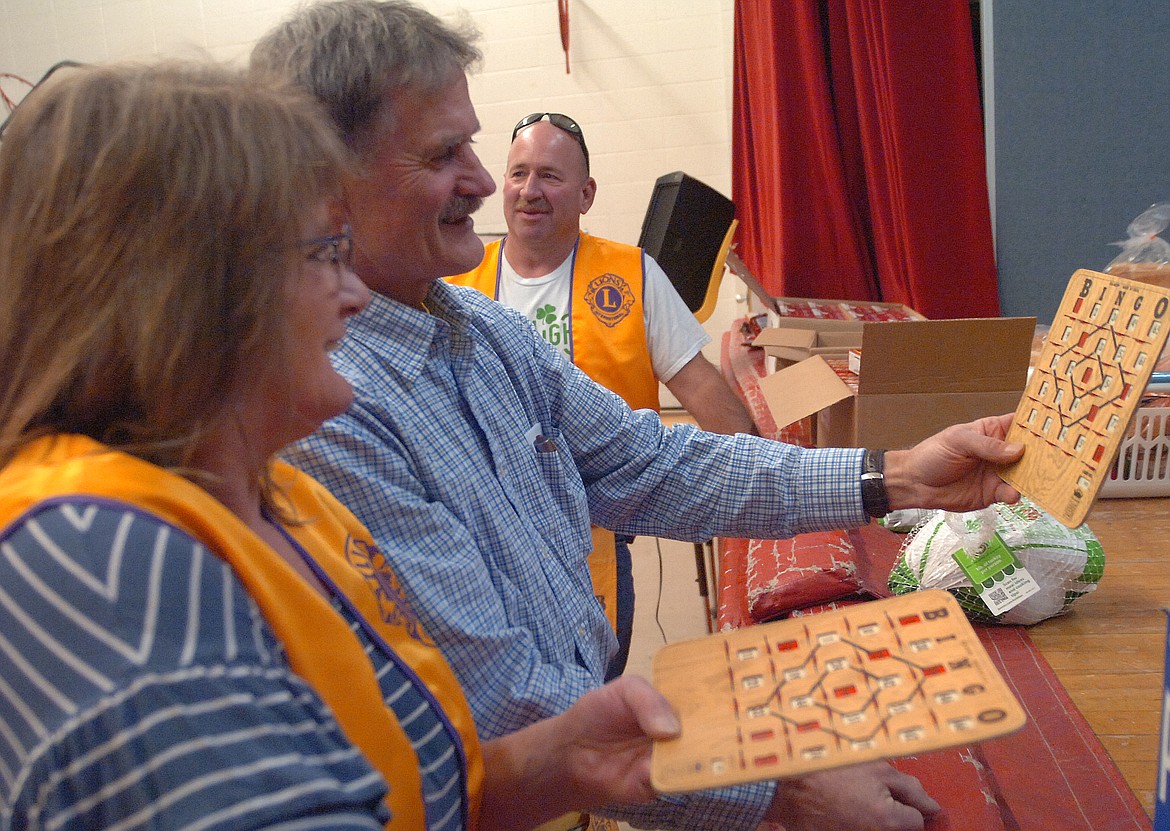 Hot Springs Lions Club members Lawrence Walchuk and Valerie Sidmore check a winning card during the OGNIB fundraiser hosted by the local club. Dave Hanson is in the background.