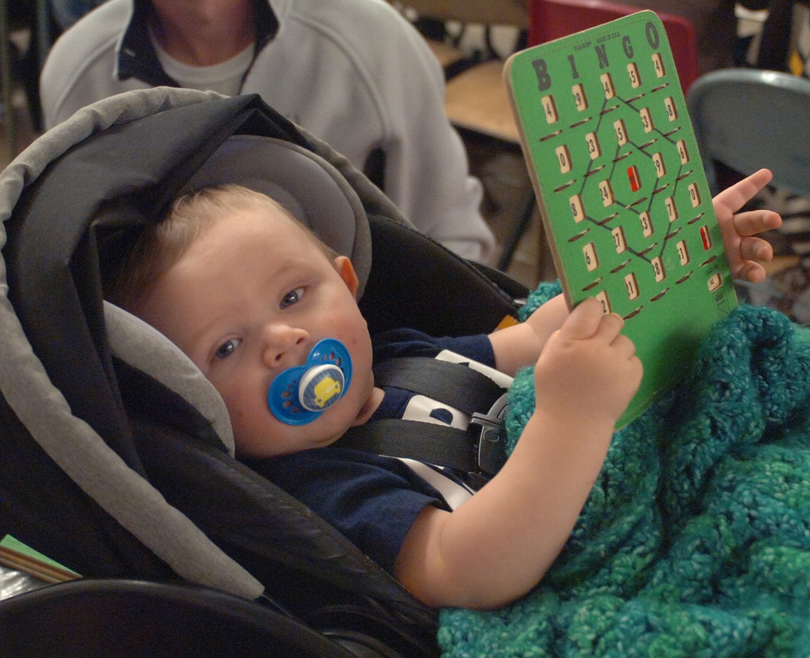 &#147;What was that number? I was distracted!&#148; That could be what 7-month-old Kason Ludeman was thinking while holding an OGNIB card during the Hot Springs Lions Club fundraiser Sunday in the Hot Springs School multi-purpose room. You&#146;re never too young to learn to play OGNIB, as Kason showed. (Joe Sova photos/Clark Fork Valley Press)