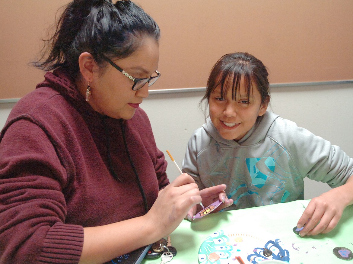 During Family Heritage Night at Linderman Elementary School, Stormie Nelson helps her daughter Araeya make a medallion that will be used as a Christmas ornament.