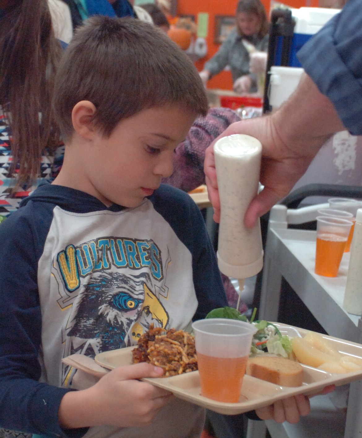 Jack Huffine, a third grader at Linderman Elementary School, gets dressing on his salad at the meal served during Family Heritage Night at Linderman Elementary School.