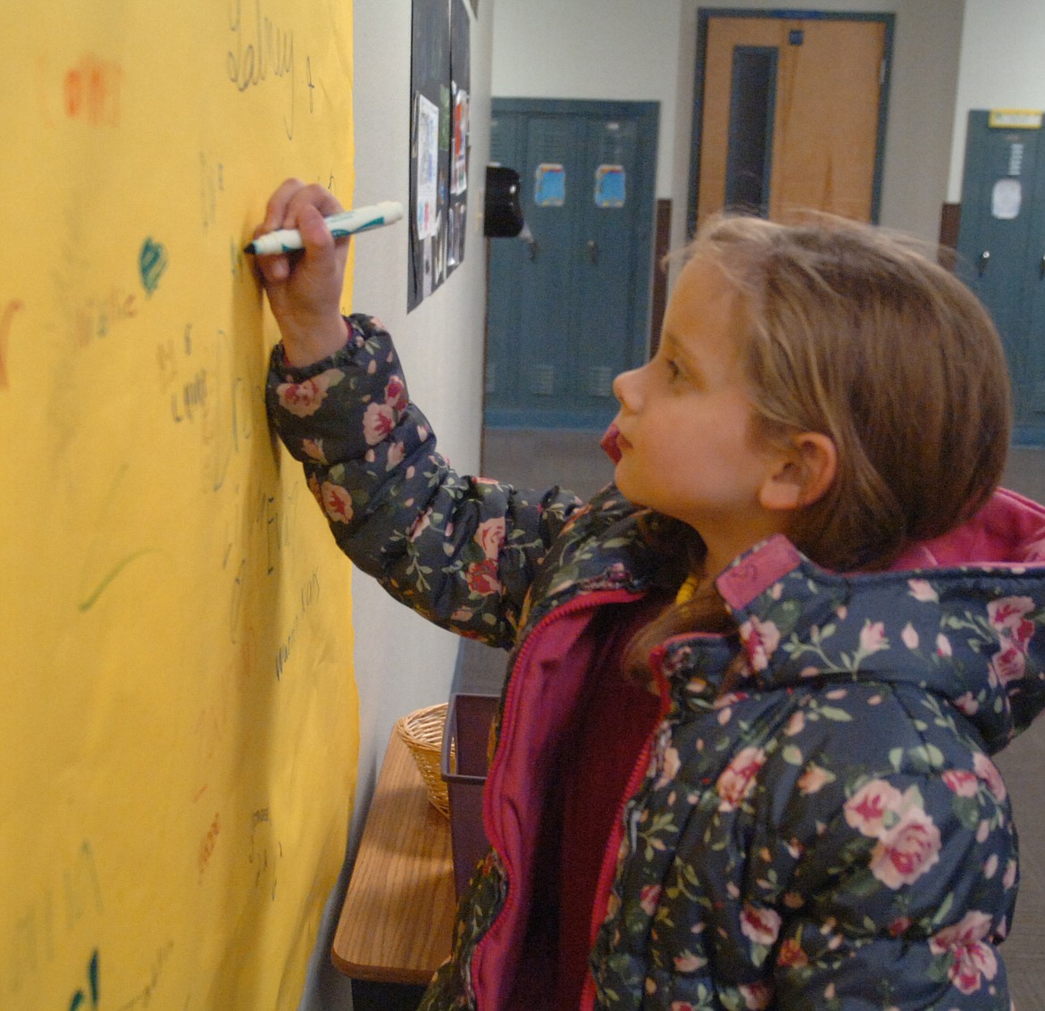 Linderman Elementary third grader Allyson Lamphere signs a banner acknowledging her attendance at Family Heritage Night at the school on the evening of Nov. 15.