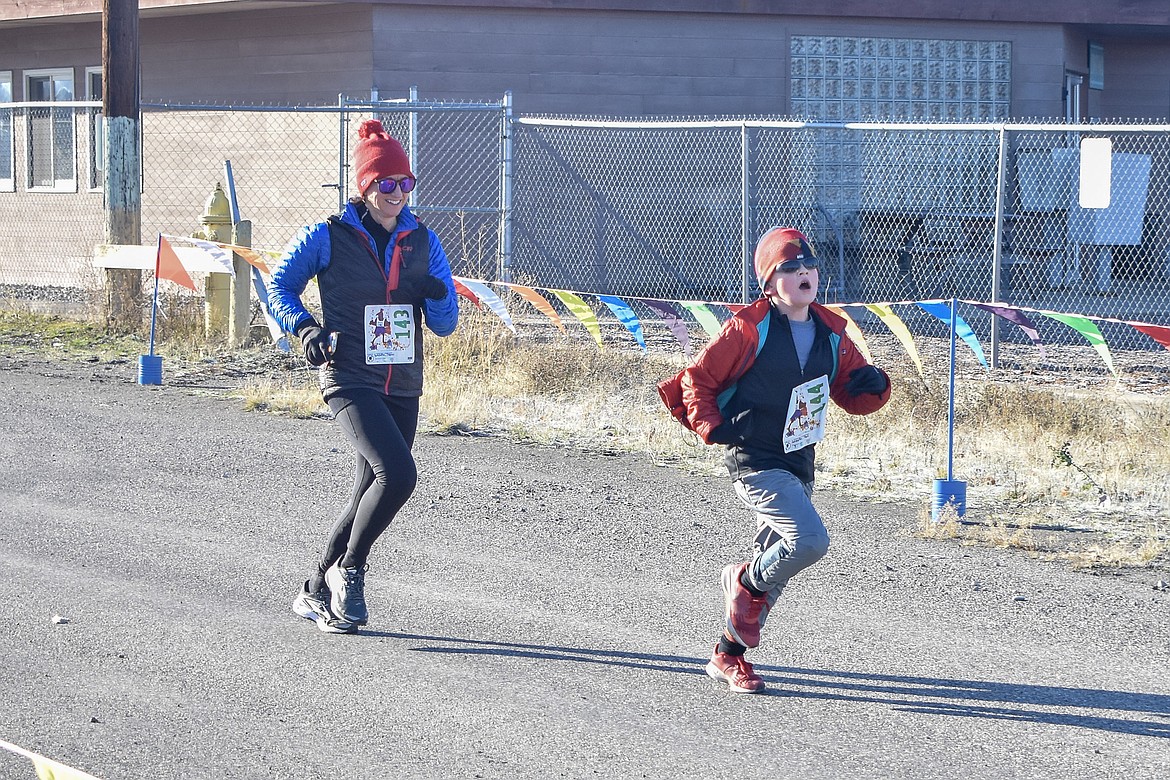 Jack Lampton sprints ahead of Debroah Lampton to the finish line at the Turkey Dash fun run in Libby Saturday. The 5k run/walk benefitted the Libby Food Pantry and Libby Pregnancy Care Center.