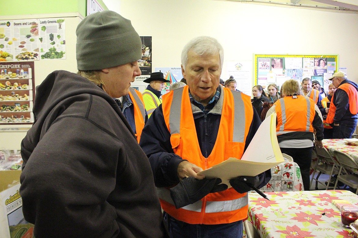 Cheryl Schweizer/Columbia Basin Herald

Tom Chaplin gives instructions to a volunteer. This was the last year on the job for Chaplin, organizer for the Thanksgiving drive-through distribution at the Moses Lake Food Bank.