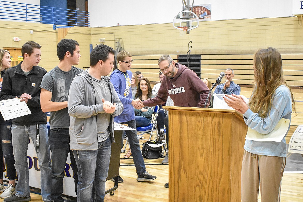Libby High School cross country Head Coach Rodd Zeiler congratulates freshman Vance Ward, who received the &#147;Most Improved&#148; team award for boys cross country during the Fall Awards Assembly Thursday. (Ben Kibbey/The Western News)