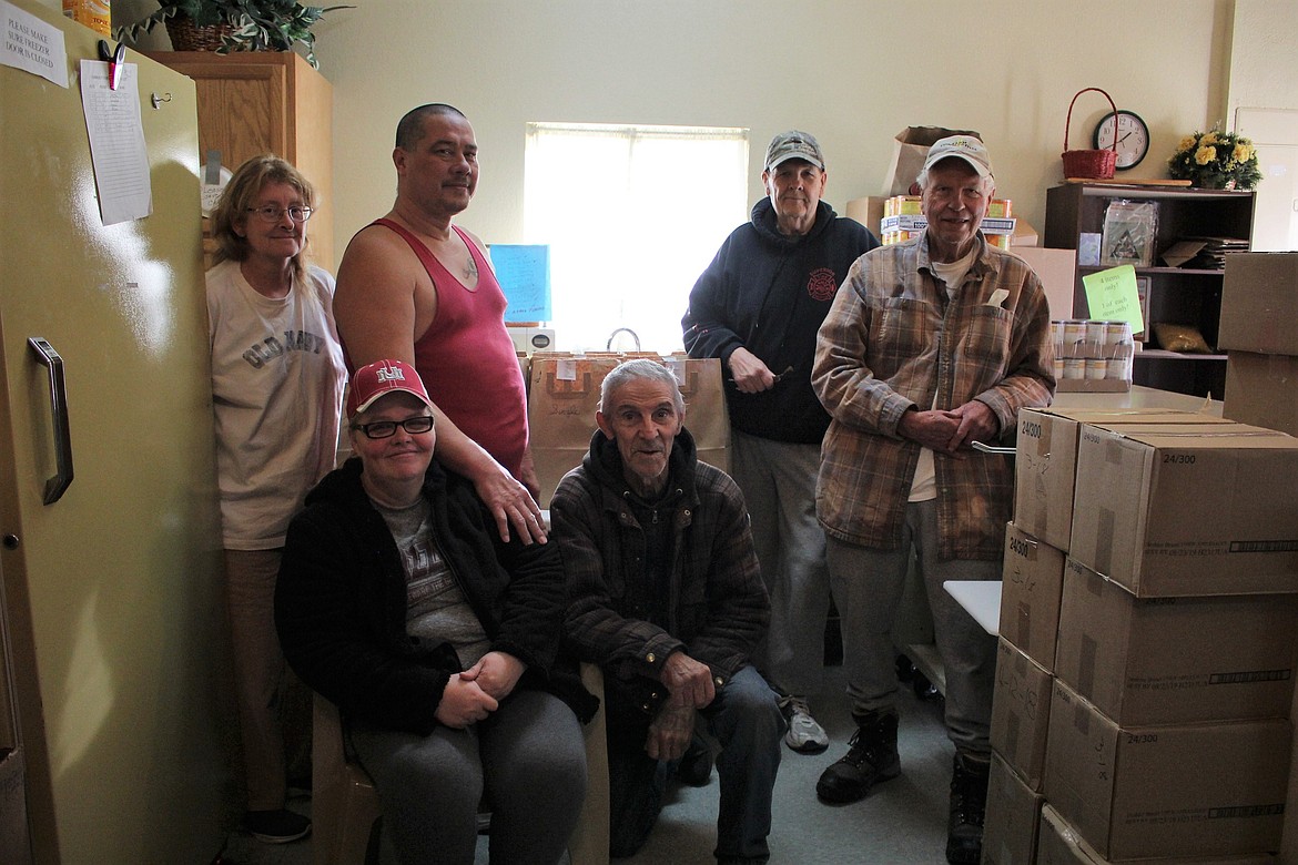 Shana Williams (far left), Tony Gramata, Robert Lyons, Gale Friesz, Amanda Gramata (seated left) and Jerry (right) volunteered last weekend at the Mineral County Food Bank, putting Thanksgiving dinner bags together to distribute to local families on Monday, Nov. 19. (Kathleen Woodford/Mineral Independent)