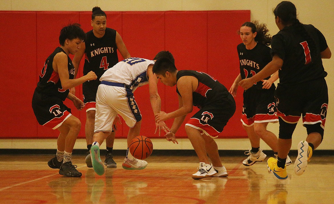 Lakeside's Talon Twoteeth, center, gathers the loose ball in Thursday night's game at Holy Family Catholic School. The visiting Knights defeated the Royals 64-50. (LOREN BENOIT/Press)