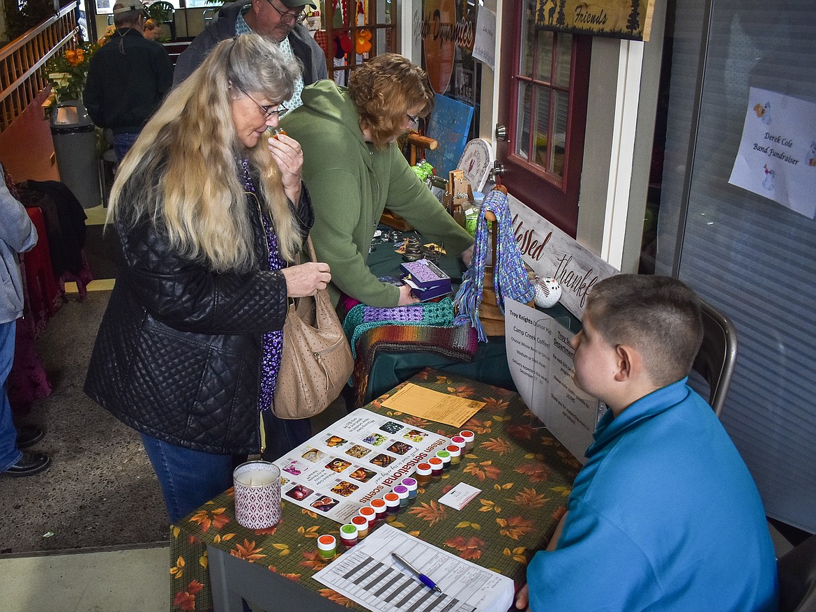 Cheryl Wolleat checks out a smell sample for the candles Libby Middle School band student Derrek Cole was selling at AuntT&#146;s Coffee Corner on Black Friday. (Ben Kibbey/The Western News)