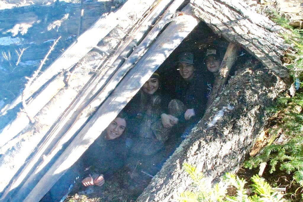 (Bottom left to top right) Talowa Fallingwater, Emily Fritz, Sydnie Cote and Jaynah Peite huddle inside their completed shelter.