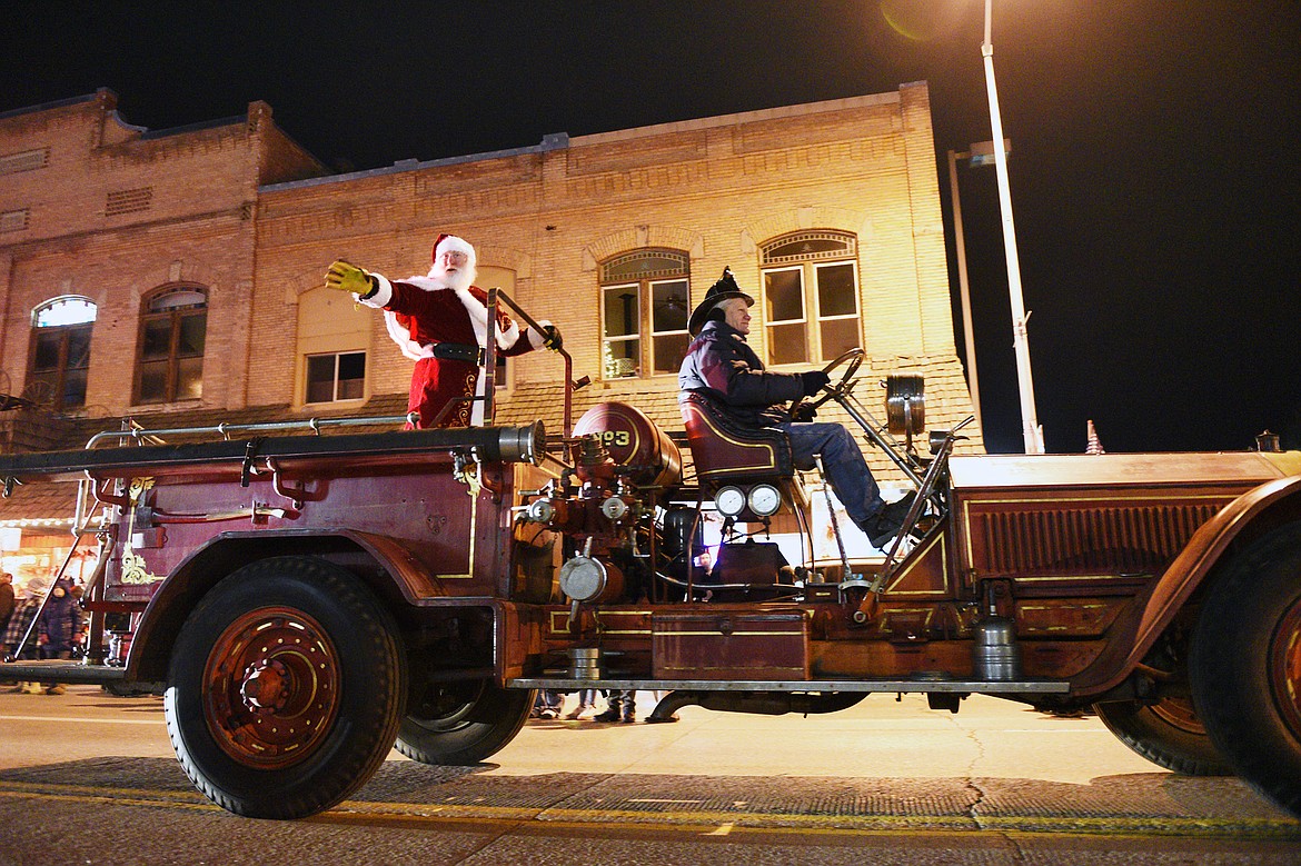 Santa Claus waves to the crowd from an antique fire engine during the 2018 Kalispell Christmas Parade on Saturday. (Casey Kreider/Daily Inter Lake)