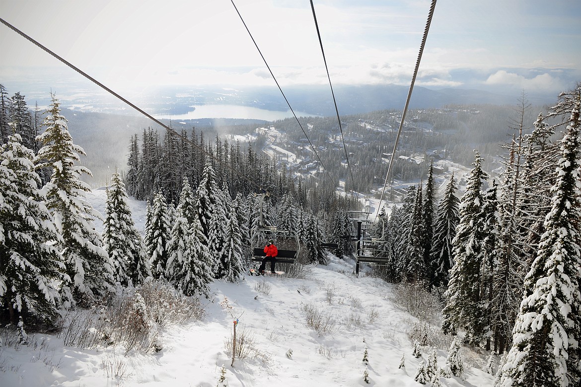 A snowboarder rides Chair 1 up to the summit on opening day at Whitefish Mountain Resort on Thursday. (Casey Kreider/Daily Inter Lake)