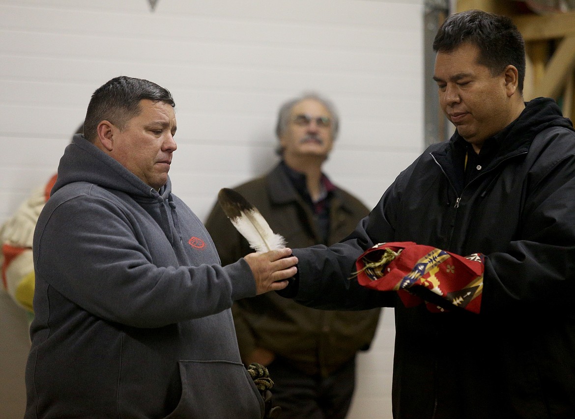 Caj Matheson, right, the Coeur d'Alene Tribe's Natural Resources director, presents an eagle feather of appreciation to Vince Peone, who helped build the aviary along with four others. (LOREN BENOIT/Press)