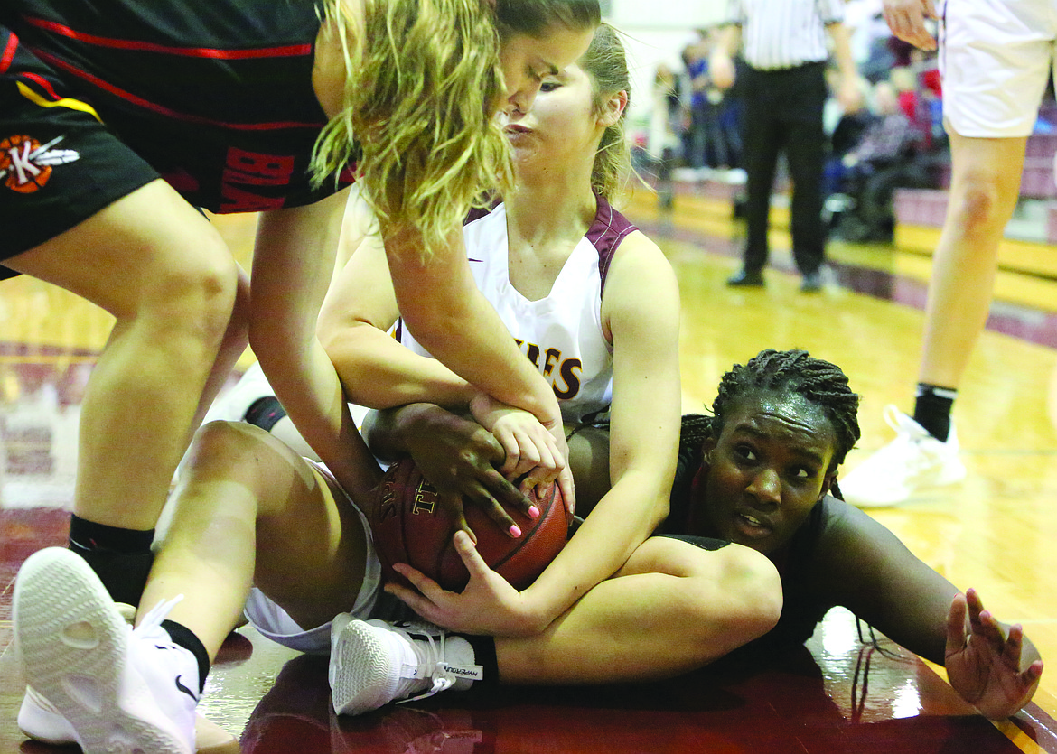 Connor Vanderweyst/Columbia Basin Herald
Moses Lake guard Kiara McPartland (center) and Kamiakin's Oumou Toure get on the floor for a loose ball.