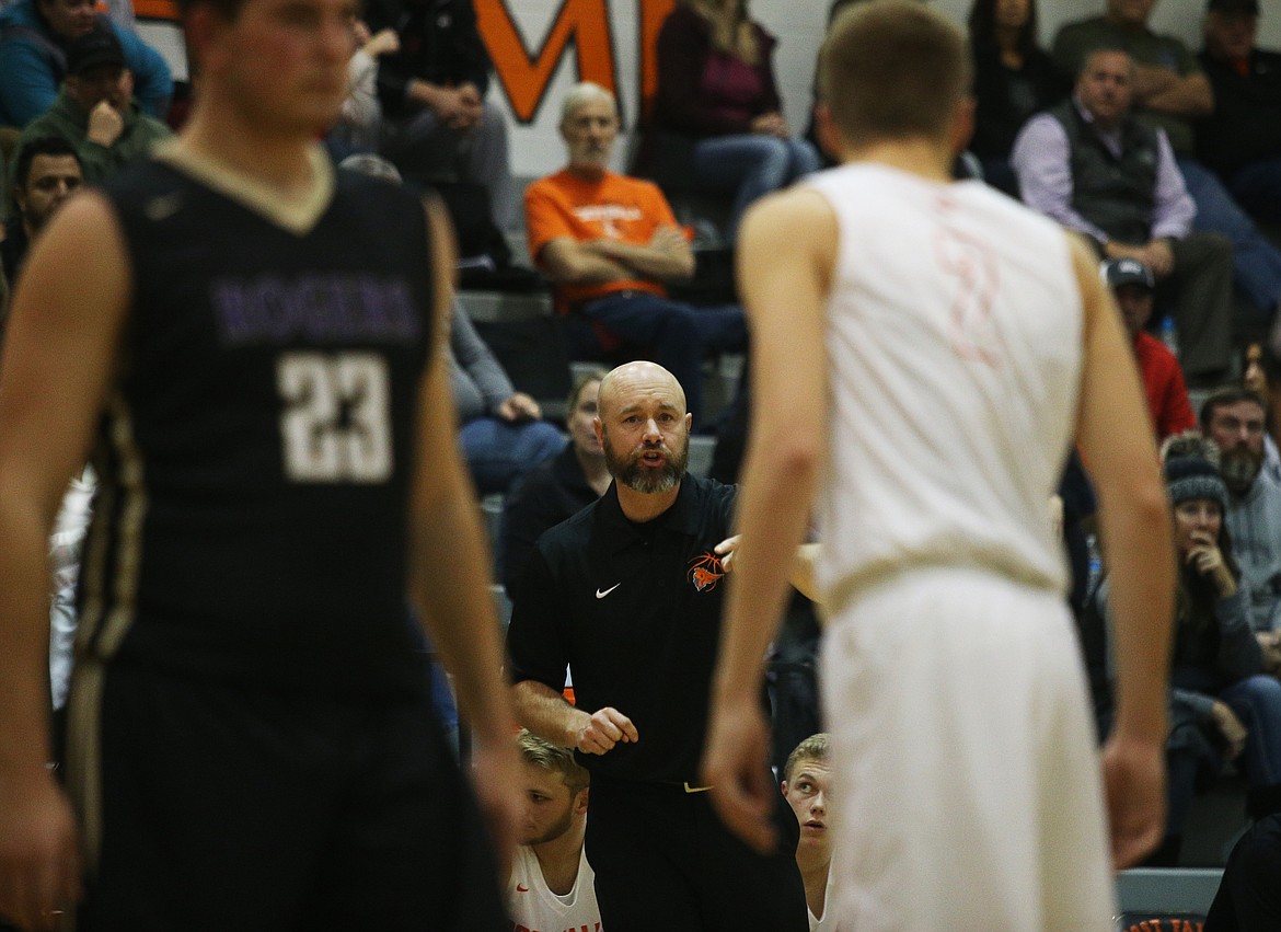 Post Falls boys head coach Mike McLean gives Colby Gennett instruction during Friday night's game against Rogers High. (LOREN BENOIT/Press)