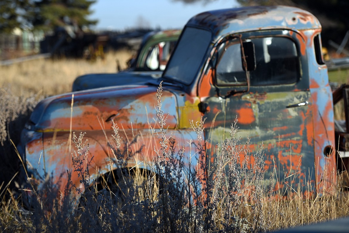 A rusted truck on the lot offers a colorful display.
