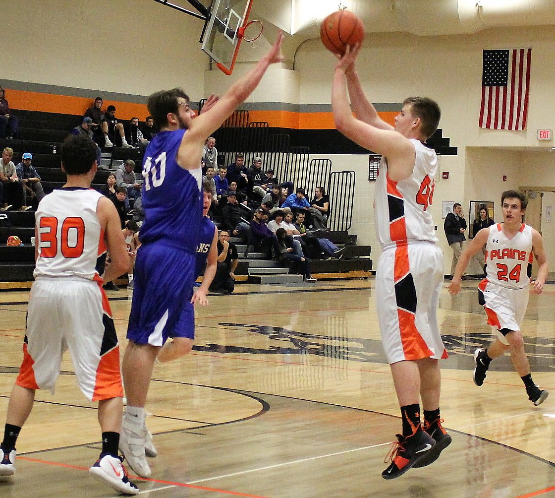 Plains senior Derick Curry launches a jumper over Carson Callison of Clark Fork during a Western C Tip-Off Tournament contest in Frenchtown. Matt McCracken (30) of Plains sets a screen and Nathan McNulty (24) moves toward the play. (Kathleen Woodford/Mineral Independent)