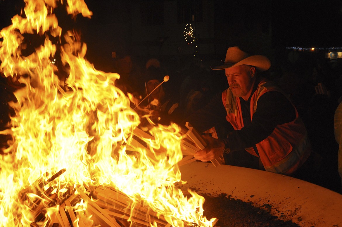 Bill Smith with the City of Polson supplies wood to a big bon fire for the parade of lights celebration. (Ashley Fox/Lake County Leader)