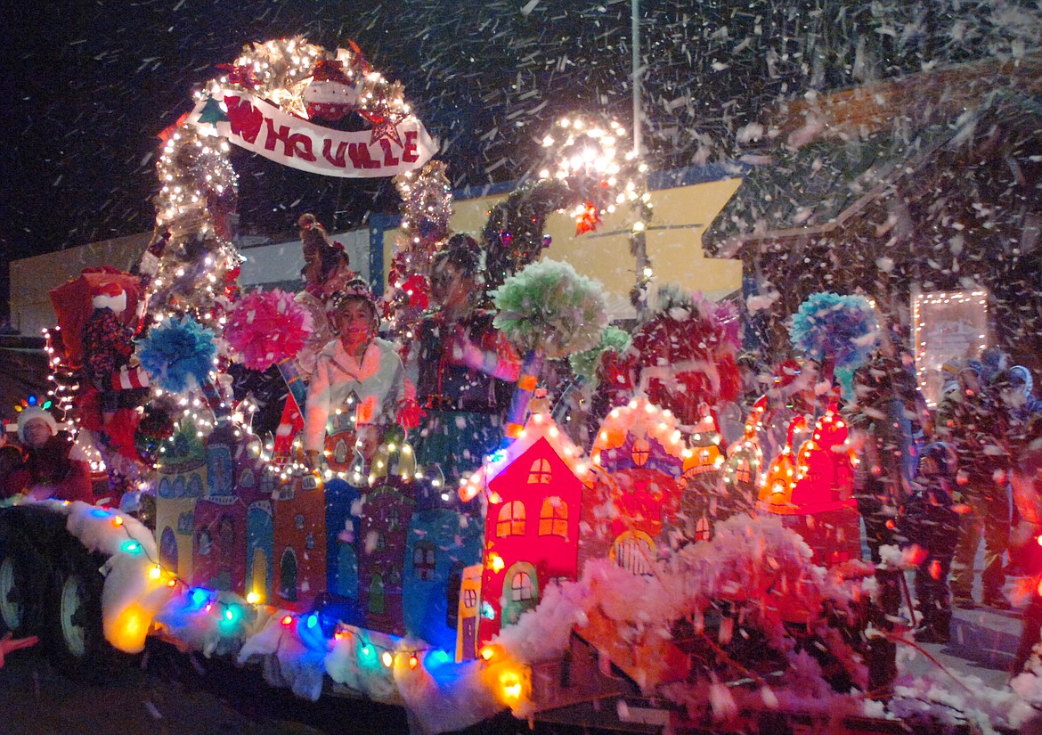 Great late-November weather graced the Polson Parade of Lights on Friday, Nov. 30. The Polson Health float, at right, was one of the most colorful. Below left, The Cox family from Dayton takes a break during the Polson Parade of Lights Friday, Nov. 30. Parents Devon and Lizzy took the kiddos. Below right, folks with Oh Well Drilling and Pumping stole the show with their float, where lights framed a house.
(Ashley Fox &amp; Joe Sova photos/Lake County Leader)