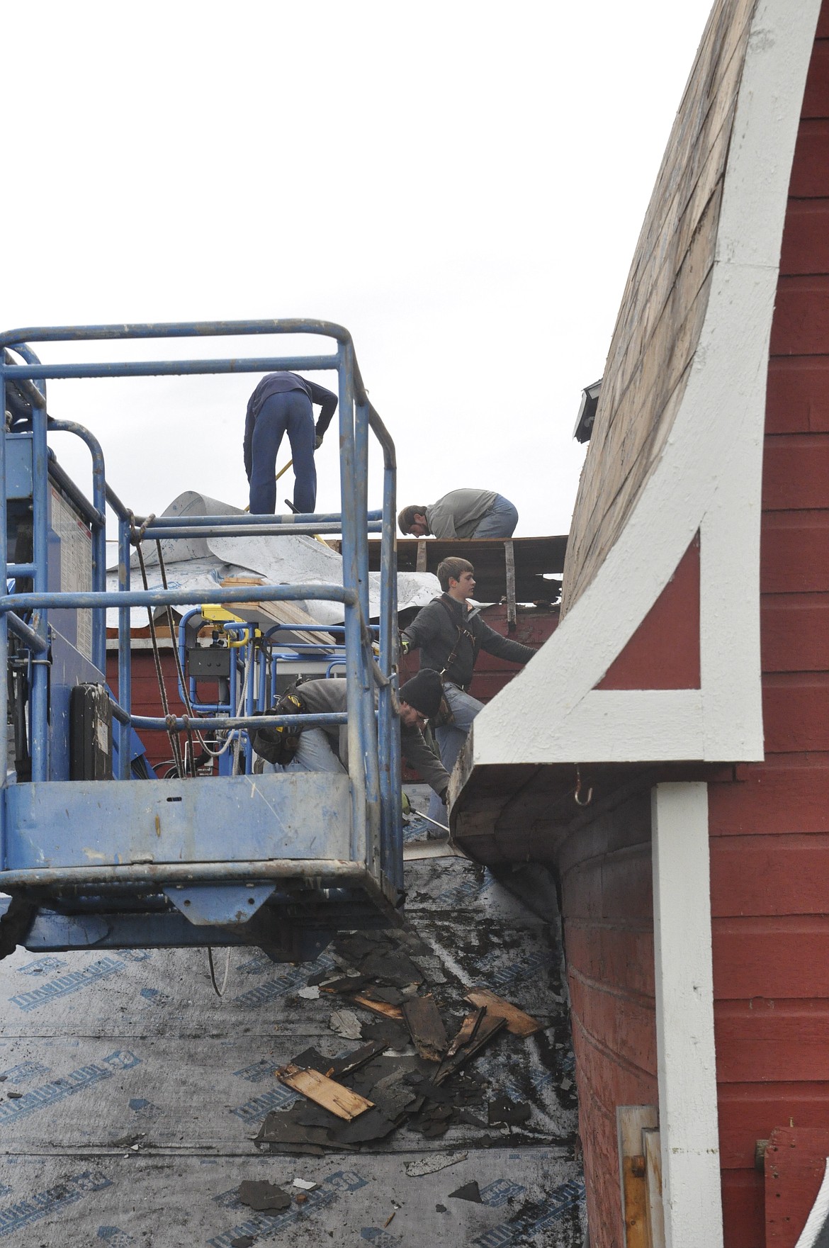 The Barn in St. Ignatius gets a new roof as a group of men work between rain showers last week. (Ashley Fox/Lake County Leader)