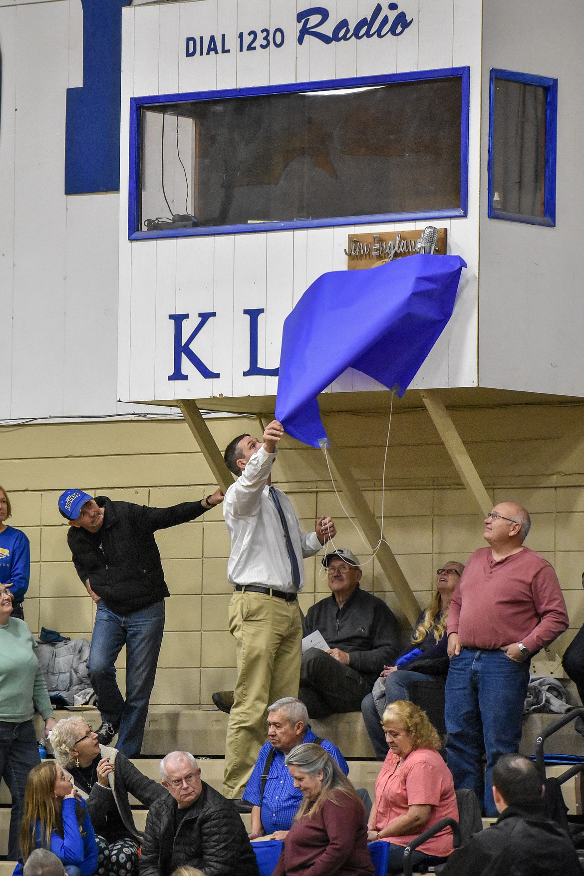 Libby High School Athletic Director Nik Rewerts unveils the plaque to Jim England during halftime of the girls basketball game Saturday. (Ben Kibbey/The Westwern News)