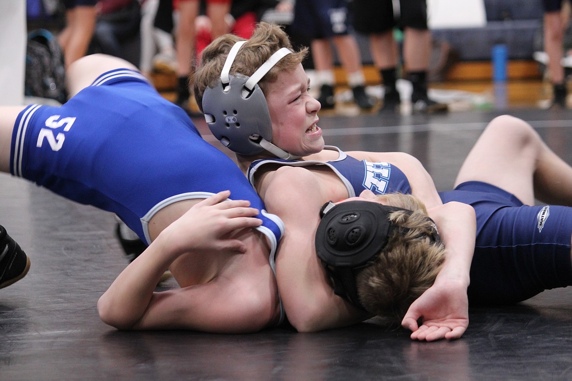 Photo by DIANA WITHERSPOON
Will Rossi of River City Middle School goes for the pin at the North Idaho district wrestling tournament on Dec. 15.