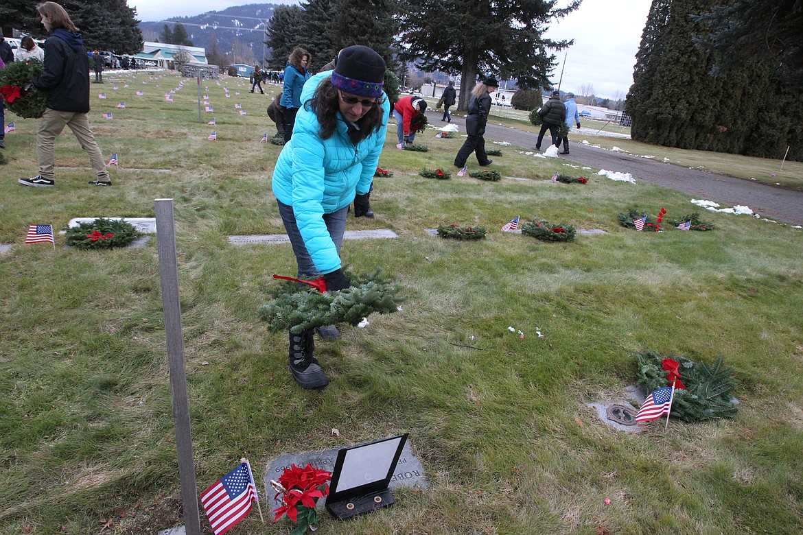 Sandra Neirinckx of Coeur d'Alene lays a wreath on the grave of Marine PFC Robert Jerry Gordon during the Wreaths Across America event Saturday morning in Coeur d'Alene Memorial Gardens. Gordon died in the Vietnam War on April 15, 1969 when he was 20. &quot;PFC Robert Jerry Gordon, you are not forgotten,&quot; Neirinckx said. (DEVIN WEEKS/Press)