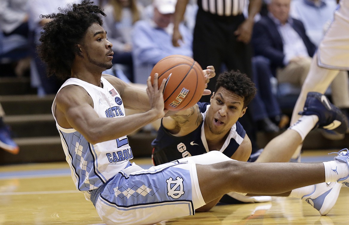North Carolina's Coby White passes the ball while Gonzaga's Brandon Clarke reaches during the second half of an NCAA college basketball game in Chapel Hill, N.C., Saturday, Dec. 15, 2018. North Carolina won 103-90. (AP Photo/Gerry Broome)