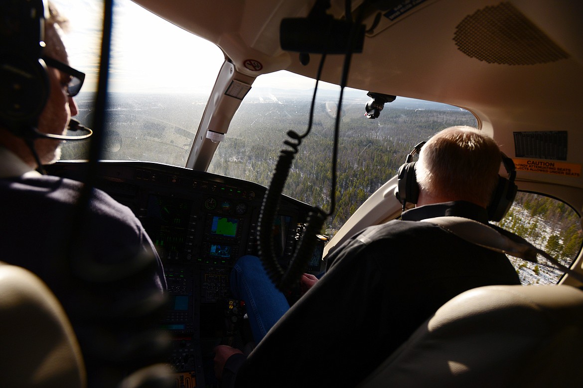 Daily Inter Lake reporter Scott Shindledecker, left, and Two Bear Air Rescue pilot Jim Pierce as the helicopter banks to the right during a RECCO technologies training exercise on Friday, Dec. 14. (Casey Kreider/Daily Inter Lake)