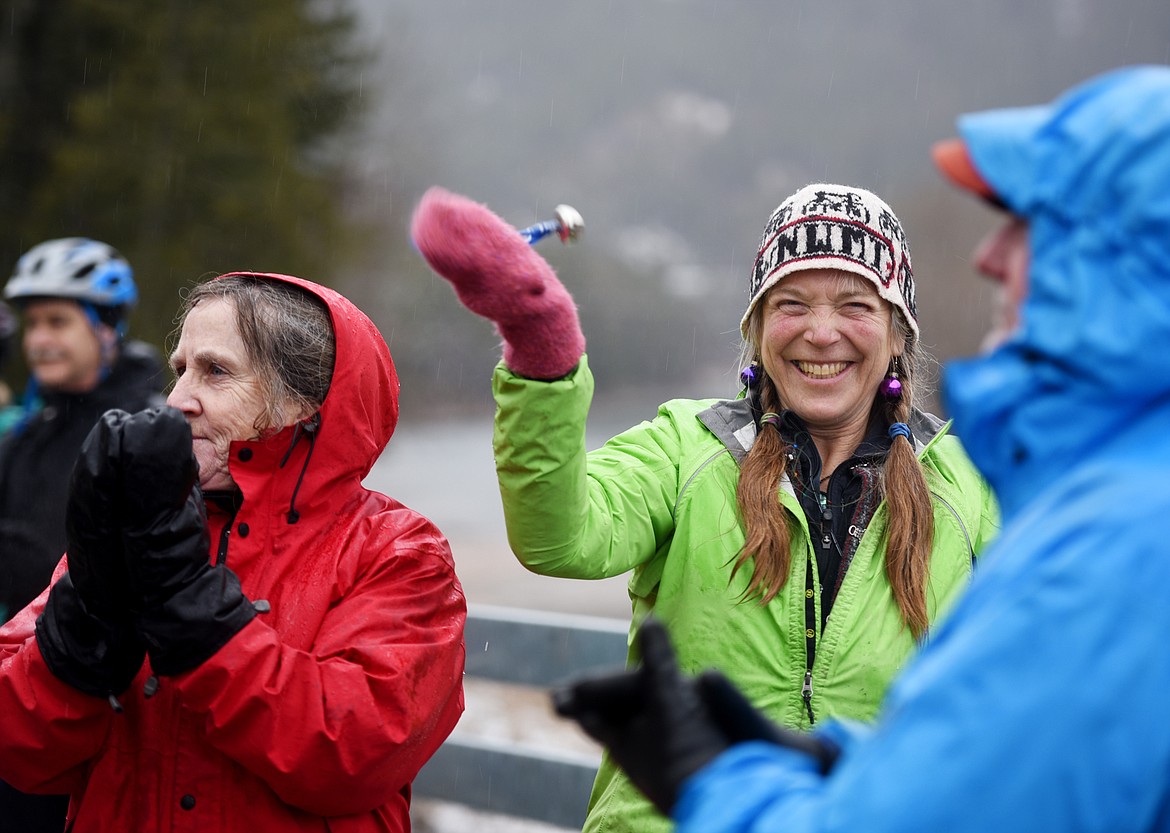 Helen Pilling of Kila cheers and rings her bell as speakers make remarks before the South Fork Bridge Ribbon-Cutting on Tuesday, December 18, in Hungry Horse. Pilling said she came because she has been with the Rails-to-Trails program from the beginning and she wanted to share in the vision of connection.(Brenda Ahearn/Daily Inter Lake)