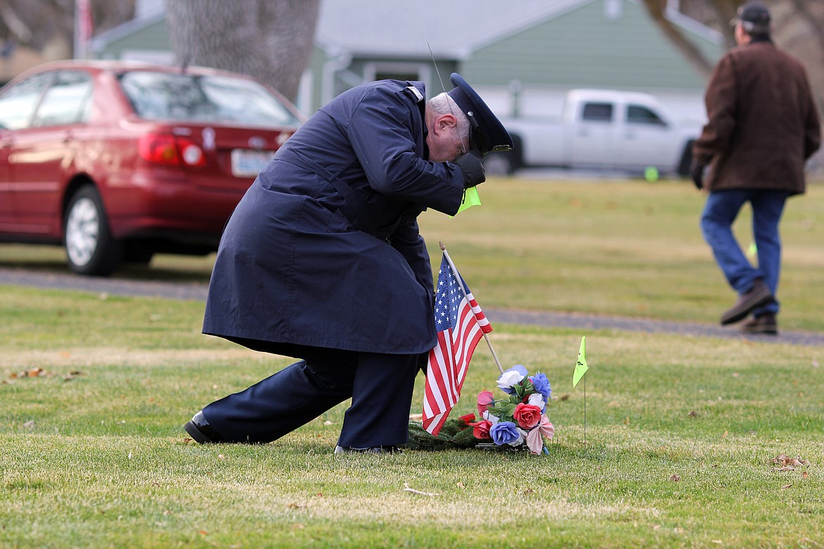 Emry Dinman/Columbia Basin Herald 
Uniformed members of the armed forces picked up flags donated by area businesses before laying wreaths on the graves.