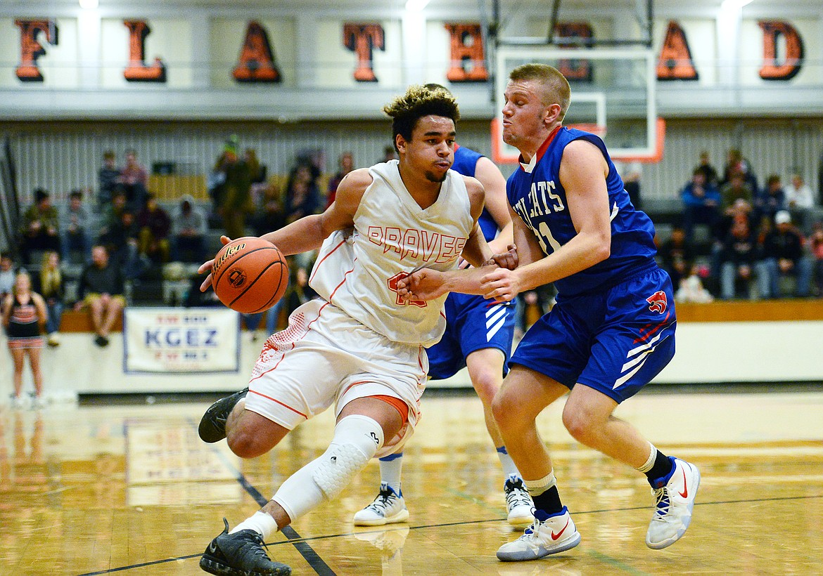 Flathead&#146;s Anthony Jones (42) drives to the basket past Columbia Falls&#146; Danny Henjum (21) at Flathead High School on Saturday. (Casey Kreider/Daily Inter Lake)