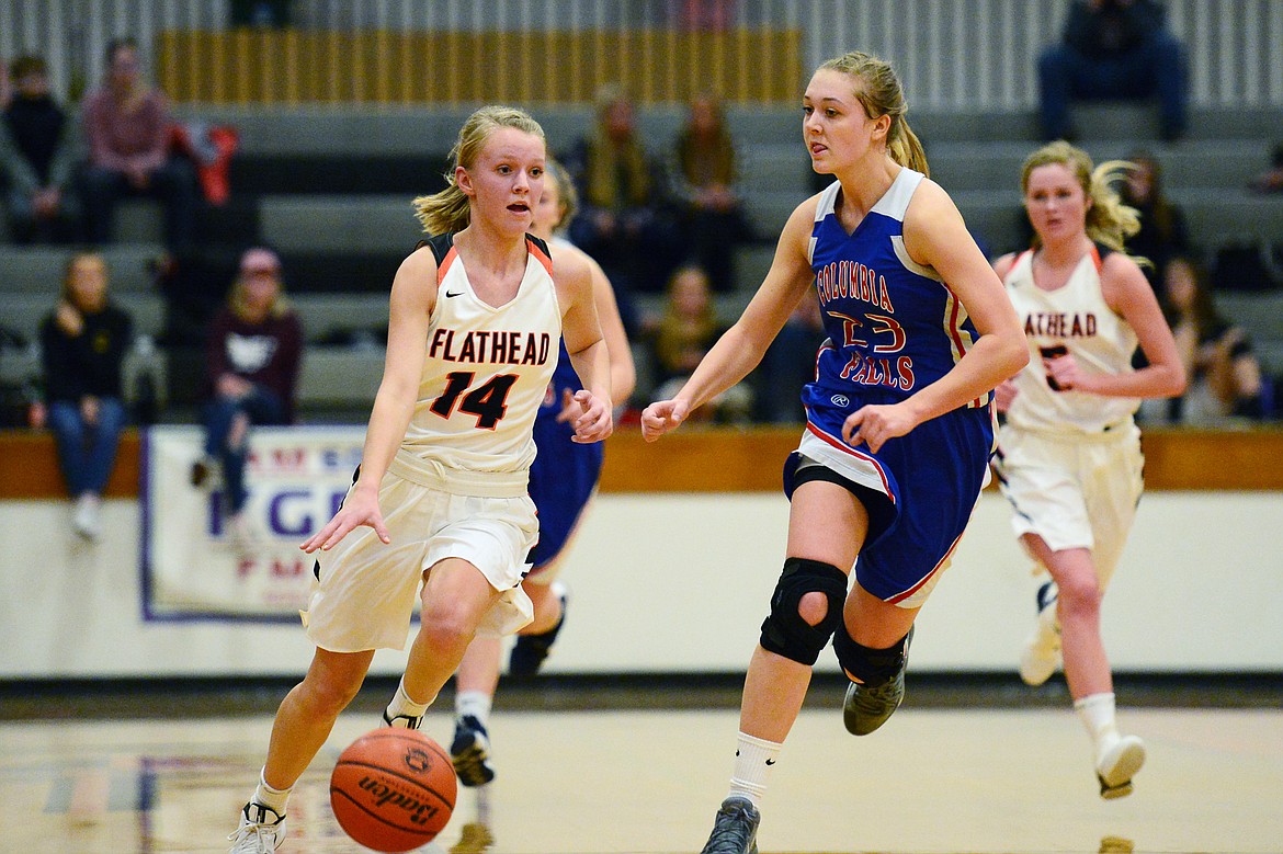 Flathead's Jenna Johnson (14) brings the ball upcourt with Columbia Falls' Ryley Kehr defending at Flathead High School on Saturday. (Casey Kreider/Daily Inter Lake)