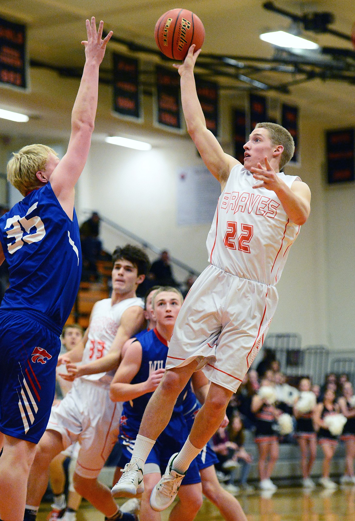 Flathead's Seth Moon (22) hits a floater in the lane over Columbia Falls' Sam Hovde (35) at Flathead High School on Saturday. (Casey Kreider/Daily Inter Lake)