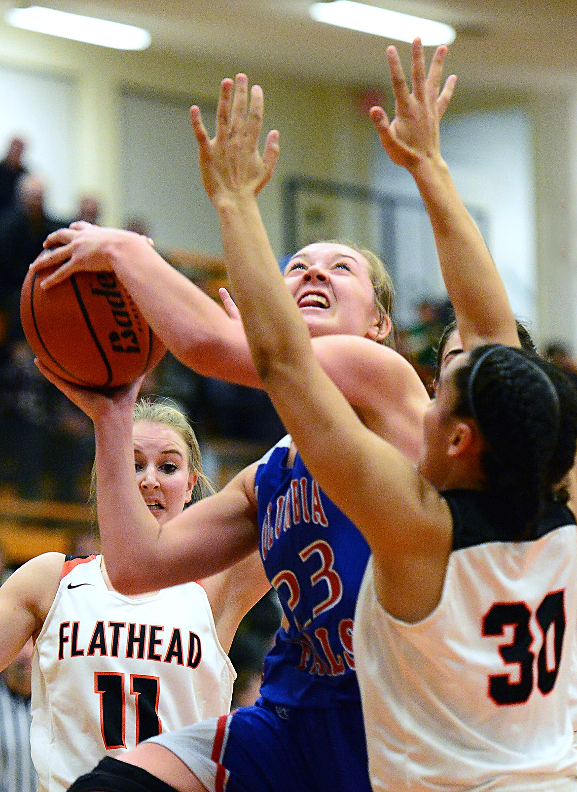 Columbia Falls' Ryley Kehr (23) powers to the basket against Flathead's Kayla Martin (30) at Flathead High School on Saturday. (Casey Kreider/Daily Inter Lake)